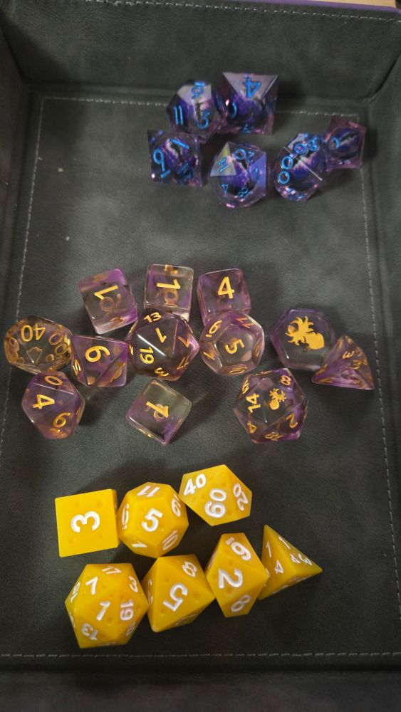 From top to bottom purple and blue drago eye dice, purple call of cthulhu dice, cheese dice