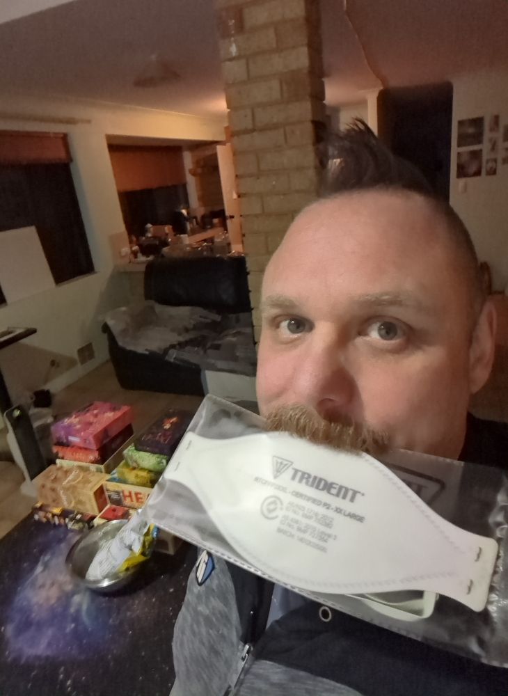 a selfie of me holding a n95 respirator in my mouth, with boardgames in the background.

Im a white man (nb) with a mohawk and a magnificent moustache 
