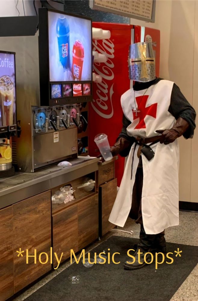 A person dressed in medieval armor stops filling a drink to react to some unseen event that presumably shocks them. A caption at the bottom reads:"Holy music stops," reminiscent of the record scratch trope.