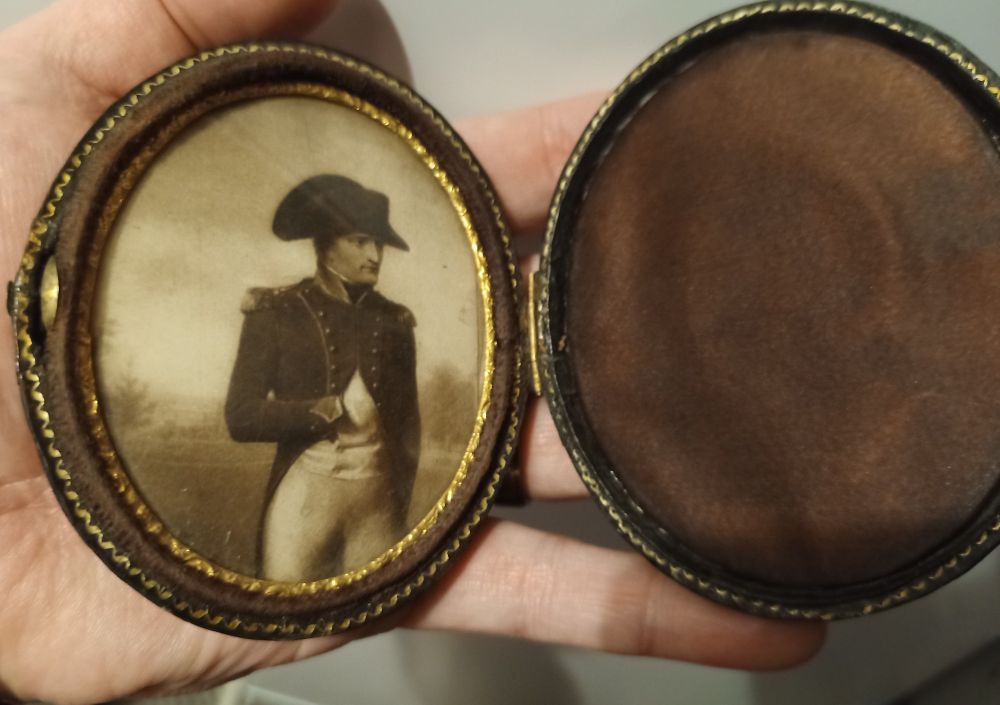 a hand holding a portrait of napoleon 