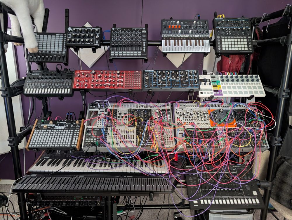 A rack of synthesizers and messy cables.
