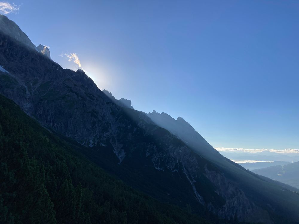Sunrise behind a mountain in the Alps.