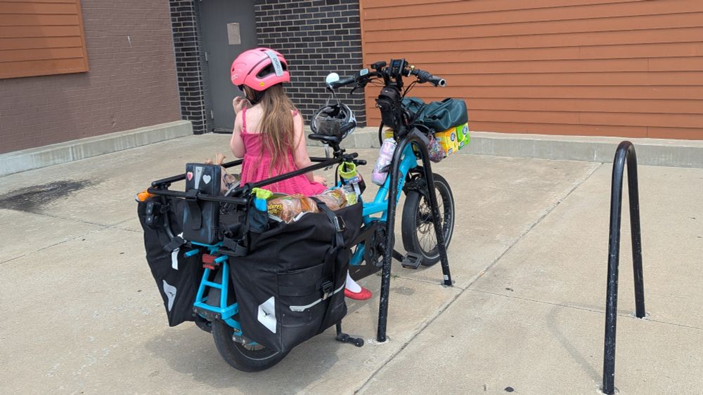 A cargo bike carrying lots of groceries and a child