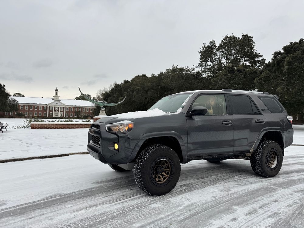 Grey 4Runner TRD Pro with bronze wheels in front of UNCW’s Soaring Seahawk statue covered in snow. 