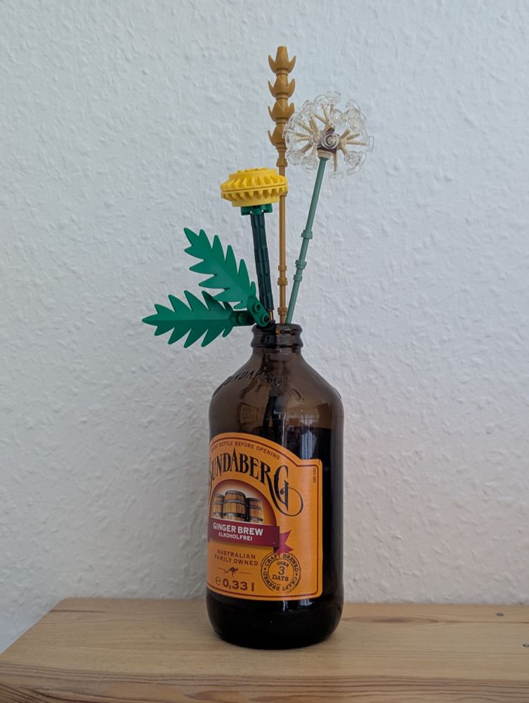 Lego Botanicals ("Field Flowers") in an empty Bundaberg Rum bottle, on a wooden shelf