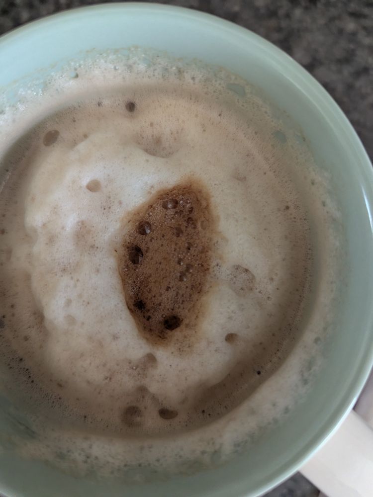 Foam on a cup of coffee forming a caffeinated borthole