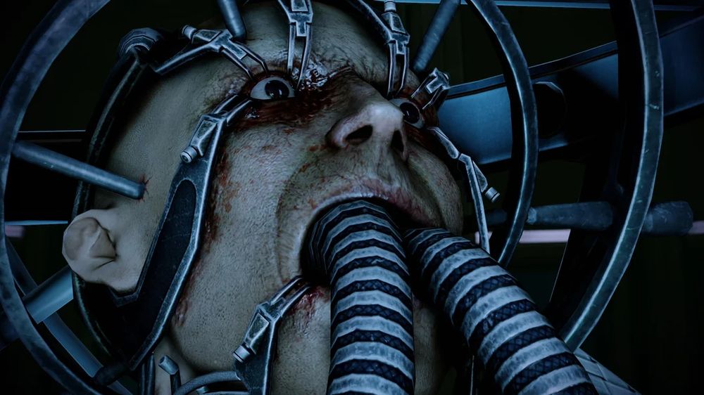 Mass Effect Overlord DLC screenshot featuring autistic savant David Archer hooked up to an AI via numerous wires and tubes going into his mouth. His eyelid are held open a la Alex from A Clockwork Orange. It does not look fun. Gavin Archer, his brother, is a massive bell end for doing this to him.