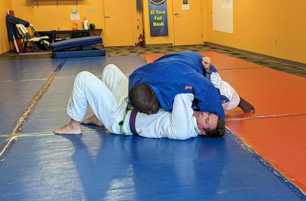 Dan practicing escaping from side control while under a larger opponent.