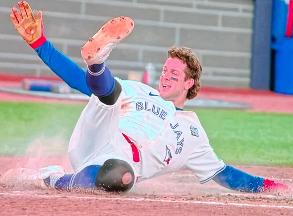 Ernie Clement of the Blue Jays sliding home. 