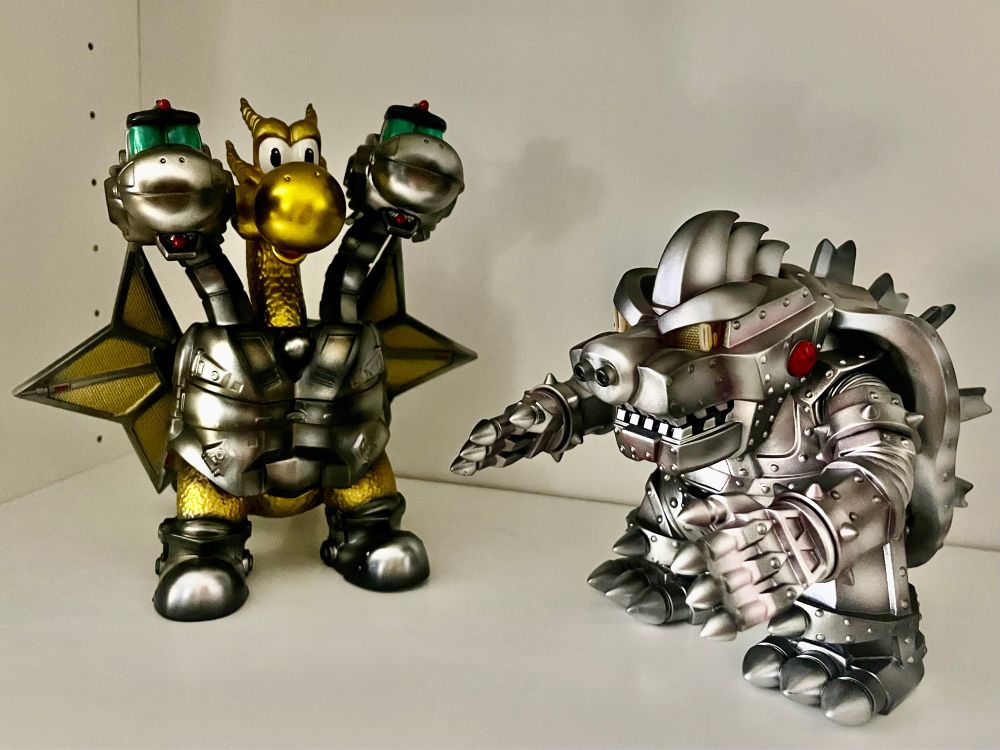 my mecha yoshi ghidorah and mecha bowser godzilla figures on a shelf