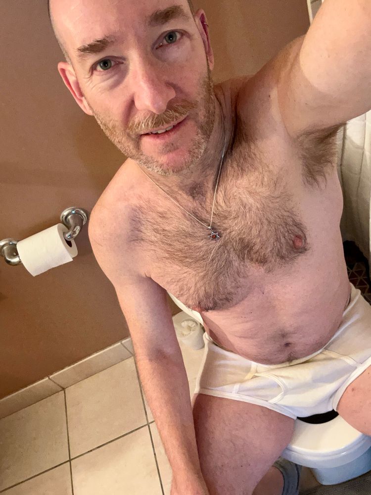 Man wearing tighty whities sitting on the toilet 