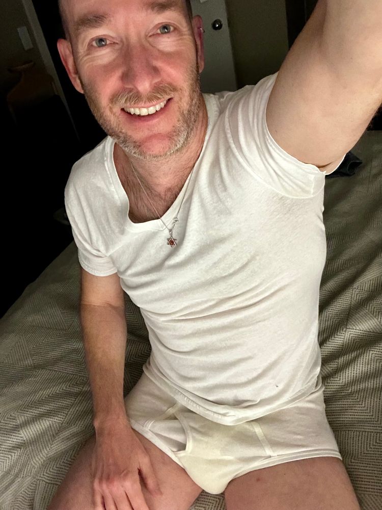 Sitting on the side of the bed selfie in some seasoned and stained tighty whities and undershirt 