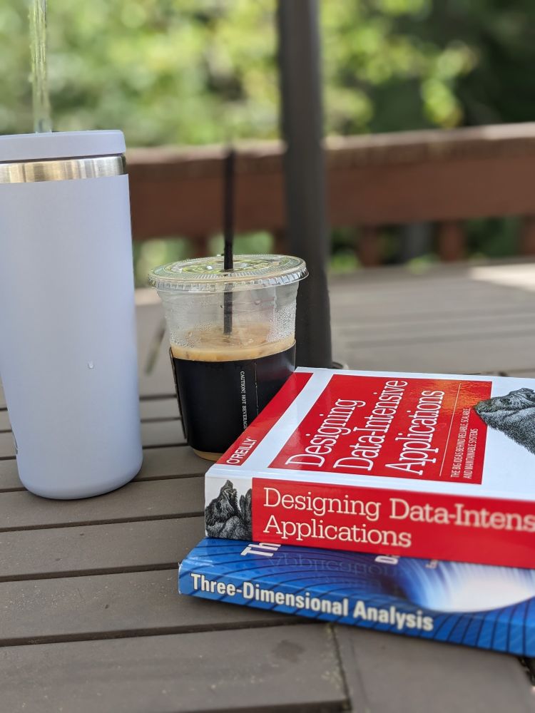 My water bottle and iced coffee t to the books: Designing Data-Intensive Applications and Three Dimensional Analysis 