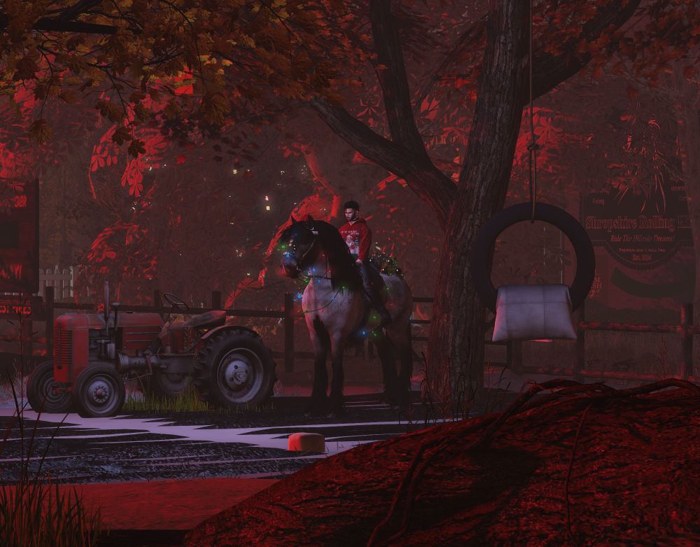 A tranquil farm scene bathed in deep red autumnal light. A man sits on a large horse adorned with glowing string lights, both framed by vibrant red-leafed trees. To the left, a vintage red tractor is parked on a path. In the foreground, a rope swing with a tire and cushion hangs from a tree. A sign in the background reads "Shropshire Rolling Hills" and advertises farm activities. The atmosphere feels rustic and cozy, with hints of festivity.