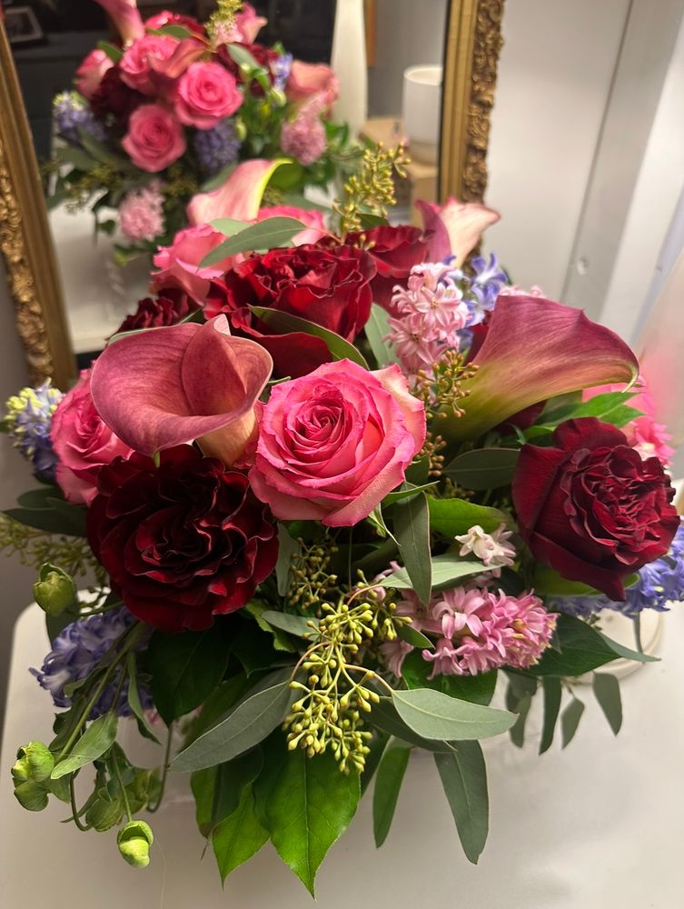 A gorgeous full bouquet of red, pink and purple flowers.