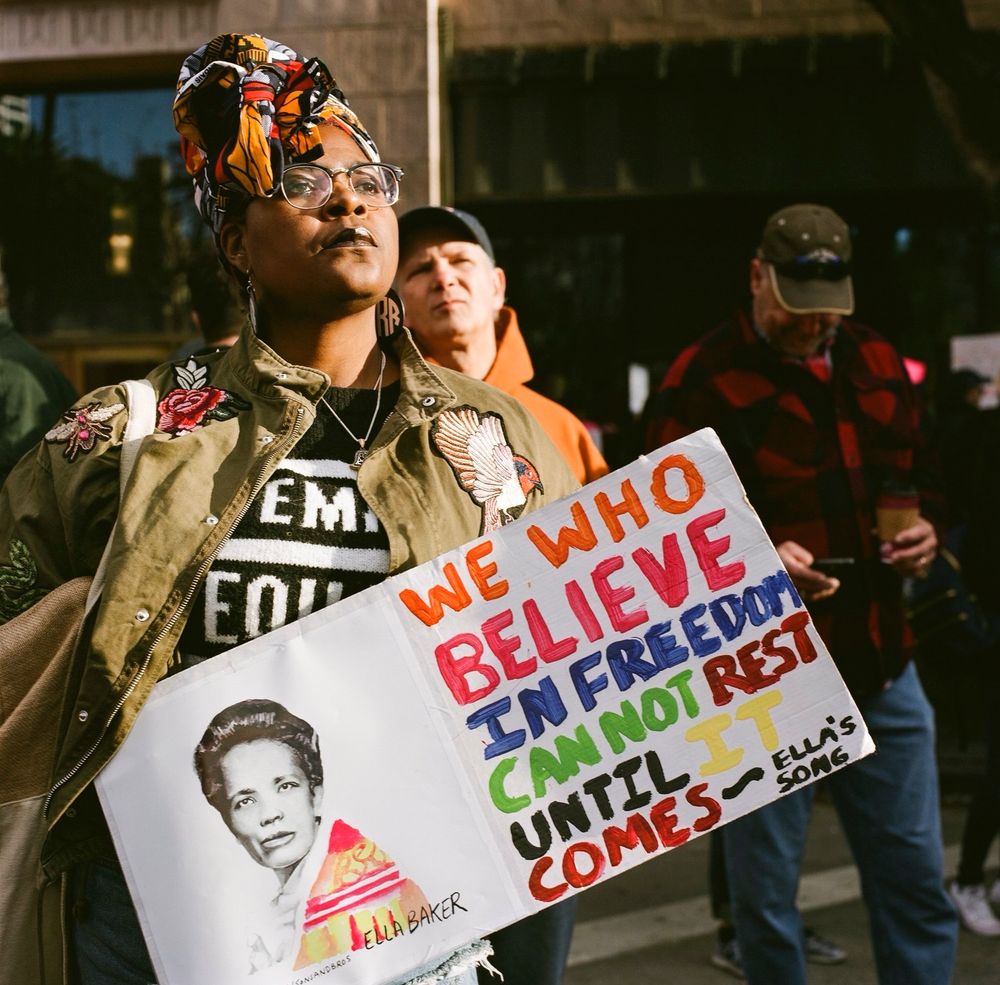 A color portrait of a black woman with a sign during the first Women’s March in Los Angeles, Calif.  