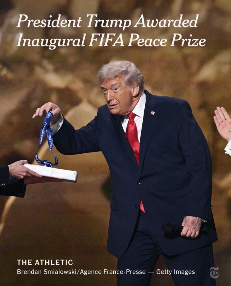 Picture of a very old looking Trump receiving a participation medal from FIFA