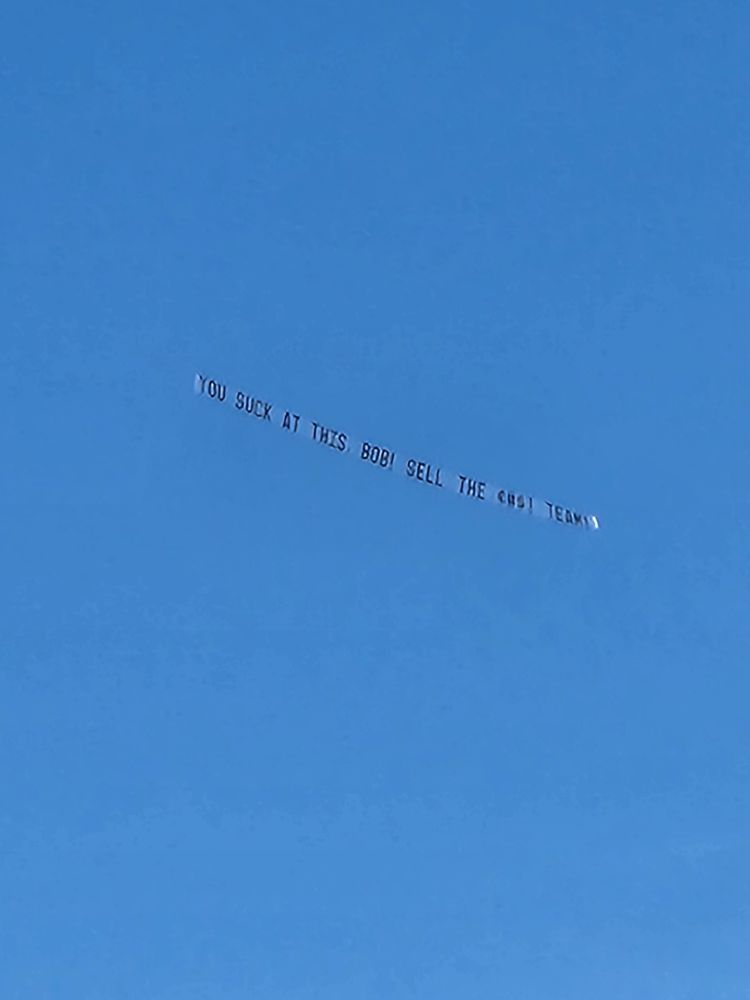 Flying banner that reads "YOU SUCK ST THIS BOB! SELL THE *** TEAM!" outside PNC park in Pittsburgh 