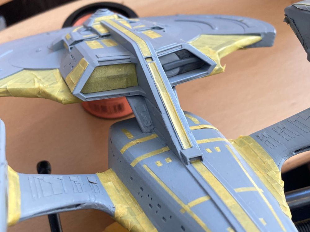 Lots more yellow masking tape being applied to dark grey sections of the 1/1400 USS Enterprise G model.