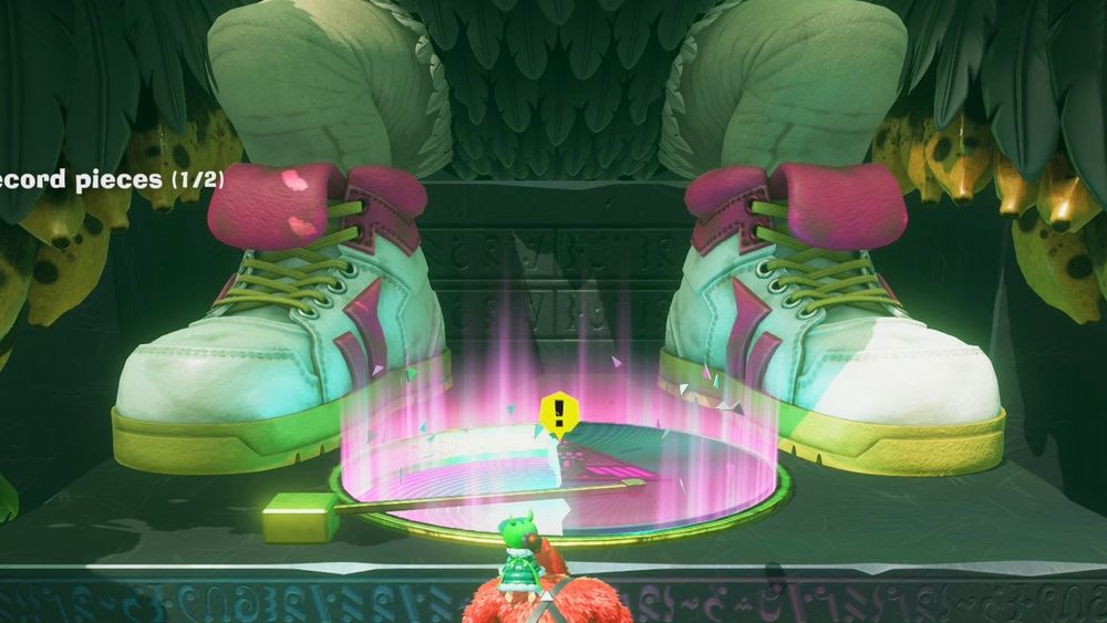 A screenshot of Donkey Kong Bananza showing DK at the bottom standing before a giant seated figure with only its feet visible. The giant is wearing a pair of dope white sneakers with pink, green and yellow accents.