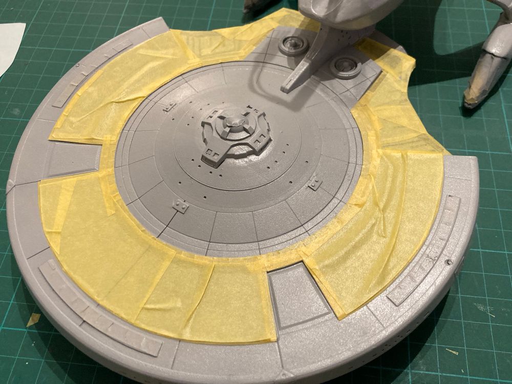 Masking off dark grey quadrants on the bottom of the USS Enterprise G’s saucer ready for a lighter grey coat.