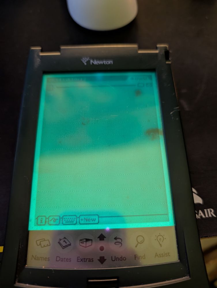an apple newton messagepad 130, with its green electro-chemiluminescent backlight illuminating the monochrome LCD, with dead spots showing