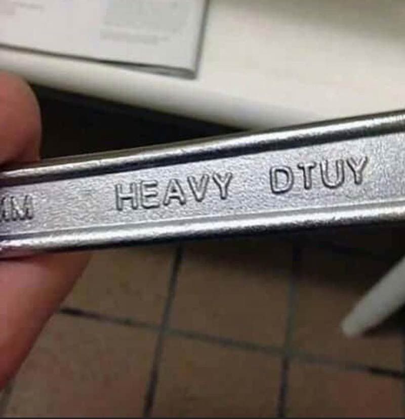 A wrench stamped with the words "HEAVY DTUY" is held by a person.