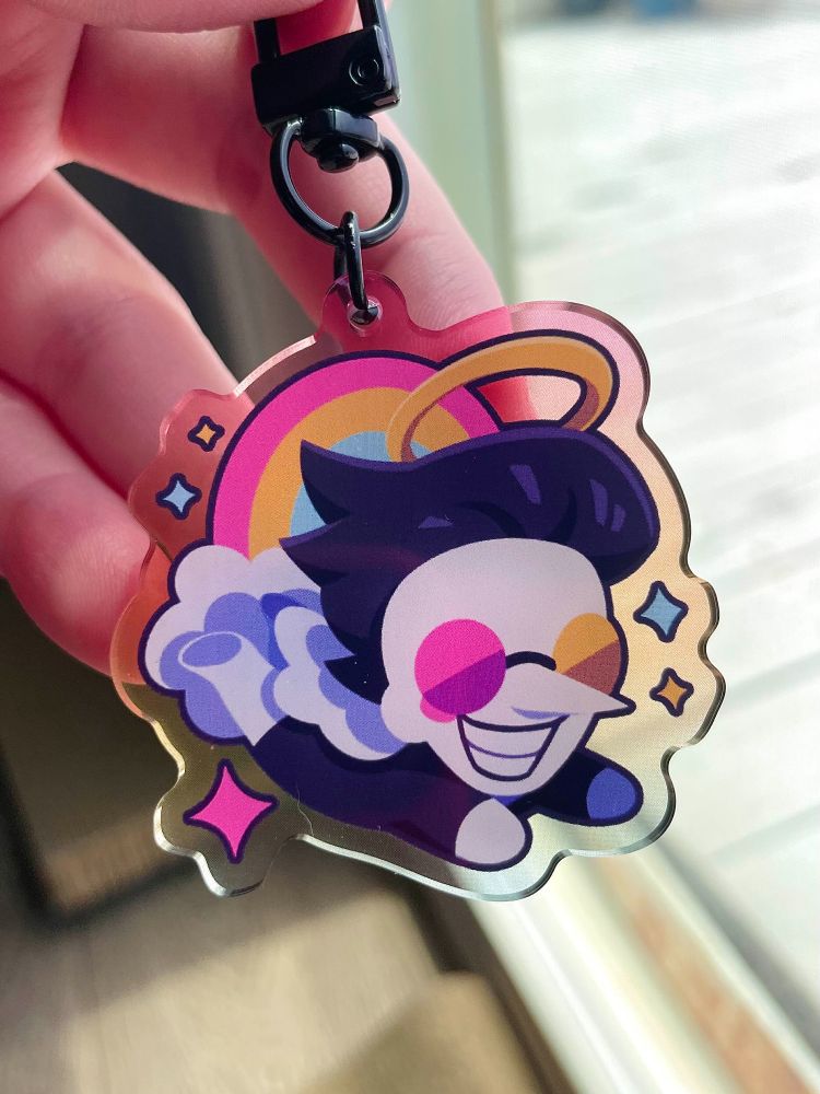 a photo of a hand holding up a keychain displaying spamton from deltarune