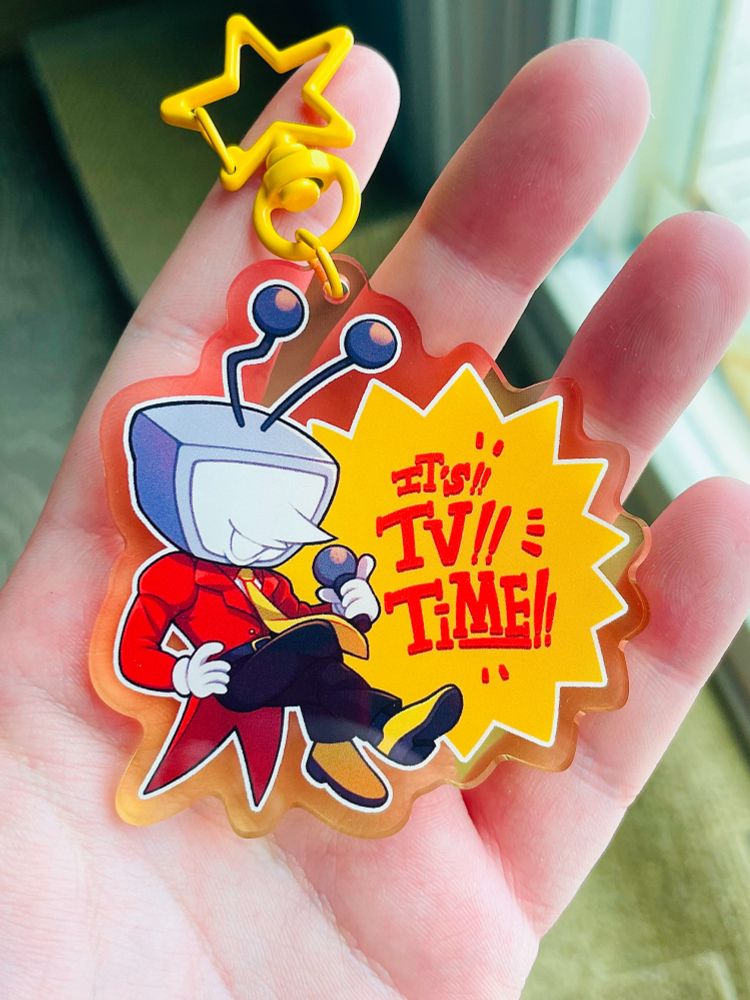 a photo of a hand holding a keychain displaying tenna from deltarune