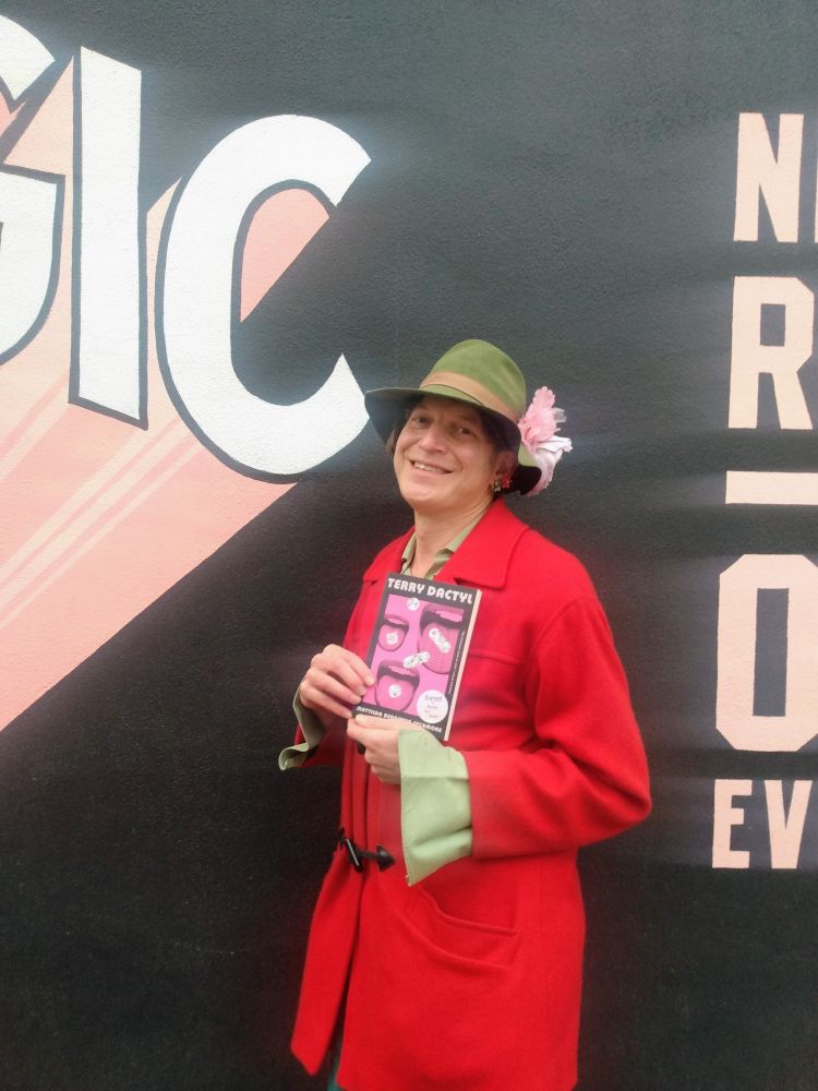 Mattilda smiling outside and holding a book