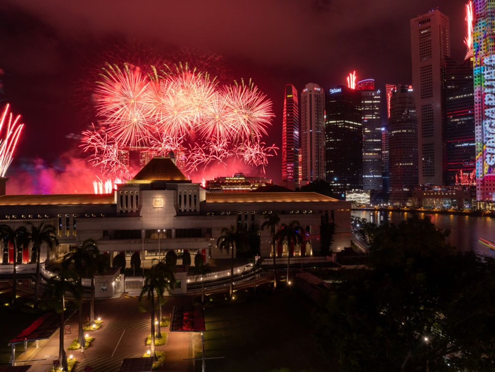 Fireworks going off behind Singapore Parliament House during National Day Parade Preview.