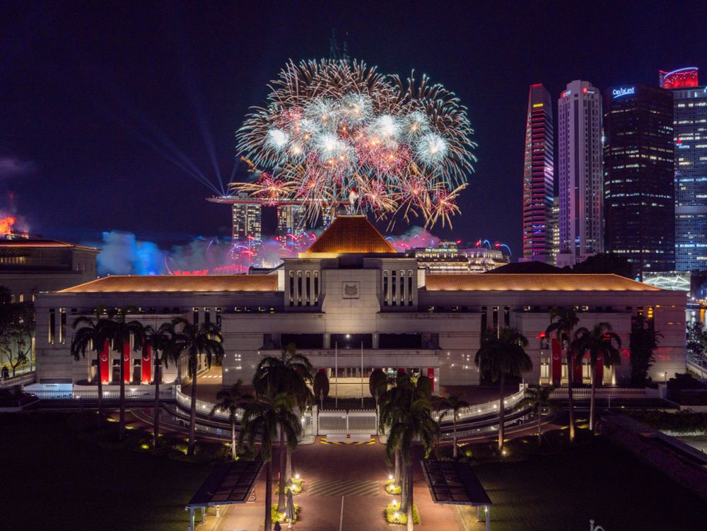 Fireworks going off behind Singapore Parliament House during National Day Parade Preview.