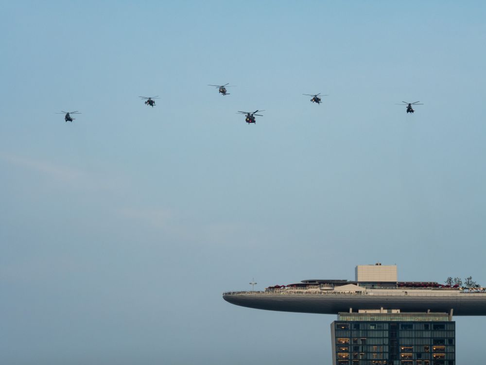 A formation of helicoptors from the Republic of Singapore Air Force flies over Marina Bay Sands during a National Day Parade preview.