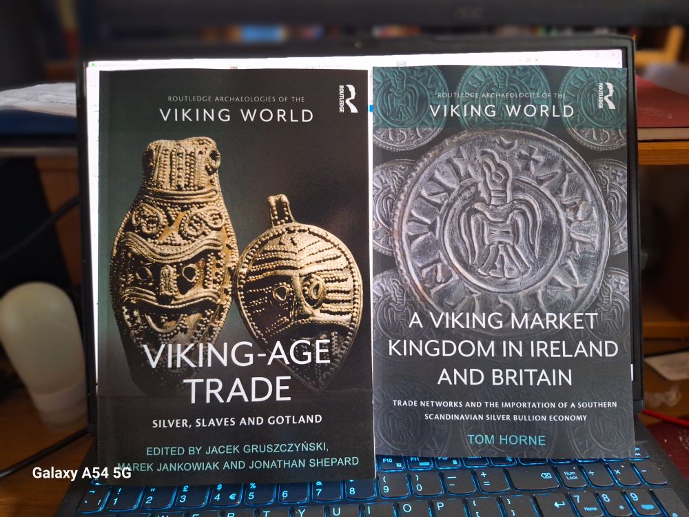 Picture of two books braced on an open laptop, from the Routledge Archaeologies of the Viking World series. Left, Viking-Age Trade: Silver, Slaves and Gotland. Right, A Viking Market Kingdom in Ireland and Britain, by Tom Horne.