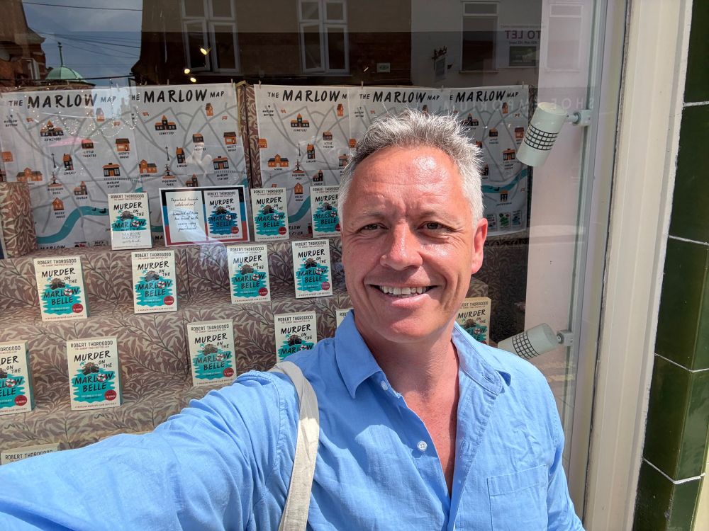 Robert outside the Marlow bookshop with his paperback in the window behind him