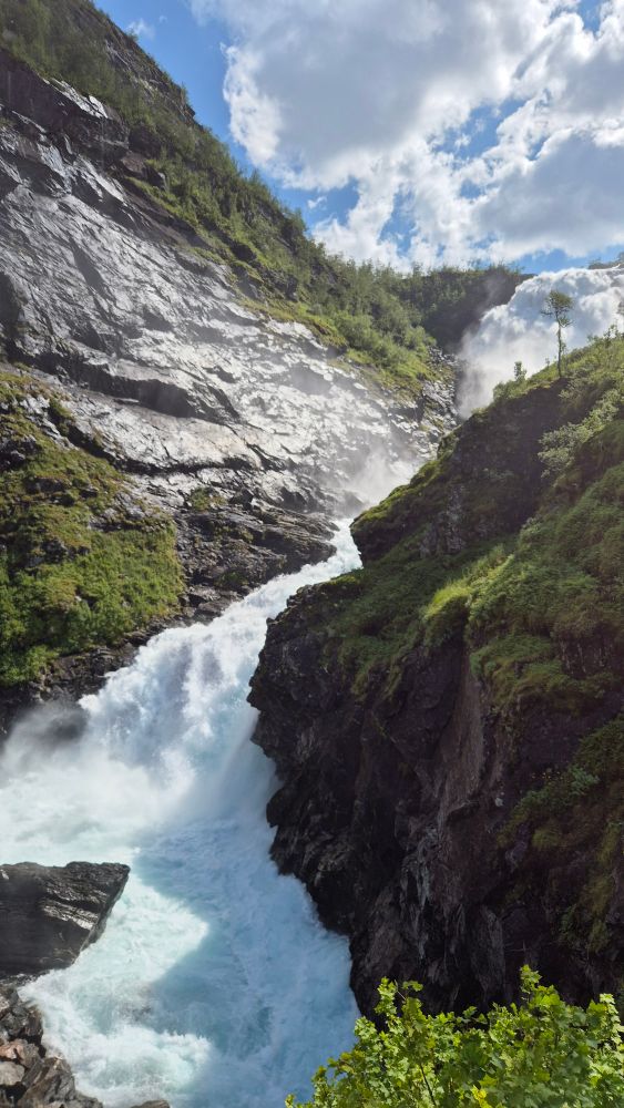 Kjosfossen, med blå og skyet himmel over. 