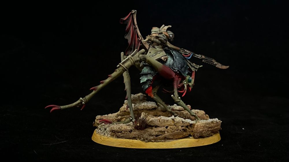 Back view of a Necromunda Ash Nomad riding a Dustback Helamite on a scenic base