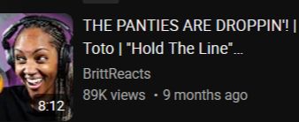 A screenshot from YouTube. On the left, a Black girl wearing black headphones and a black t-shirt is smiling widely while looking to the left. The title of the video is "The panties are droppin! Toto 'Hold the Line'". The channel name is BrittReacts.