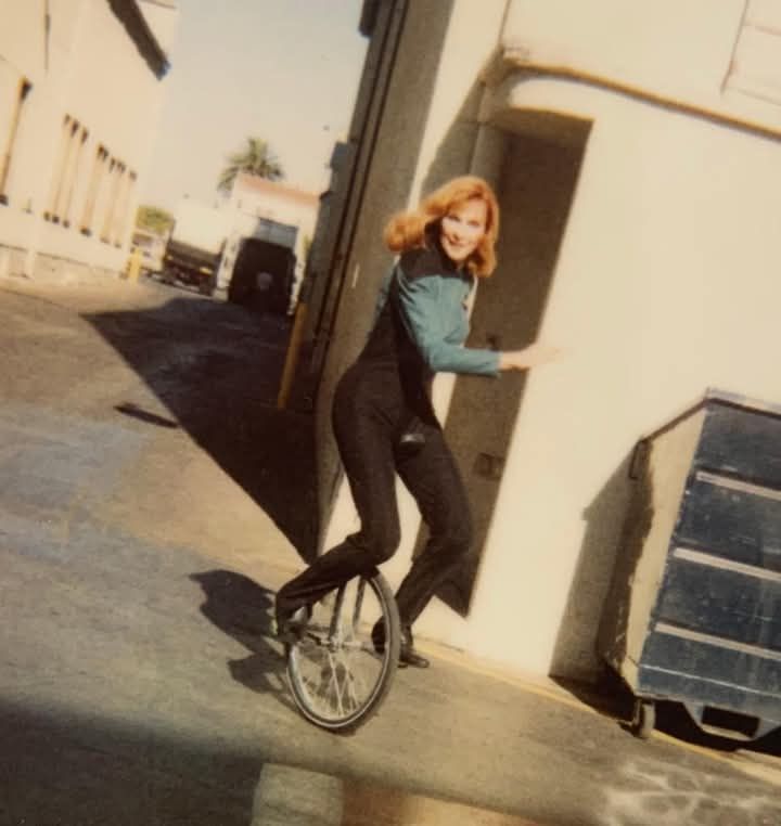 Actor Gates McFadden, in her Dr. Beverly Crusher costume from Star Trek - The Next Generation, riding on a unicycle on the Universal Studios backlot.

You're welcome.