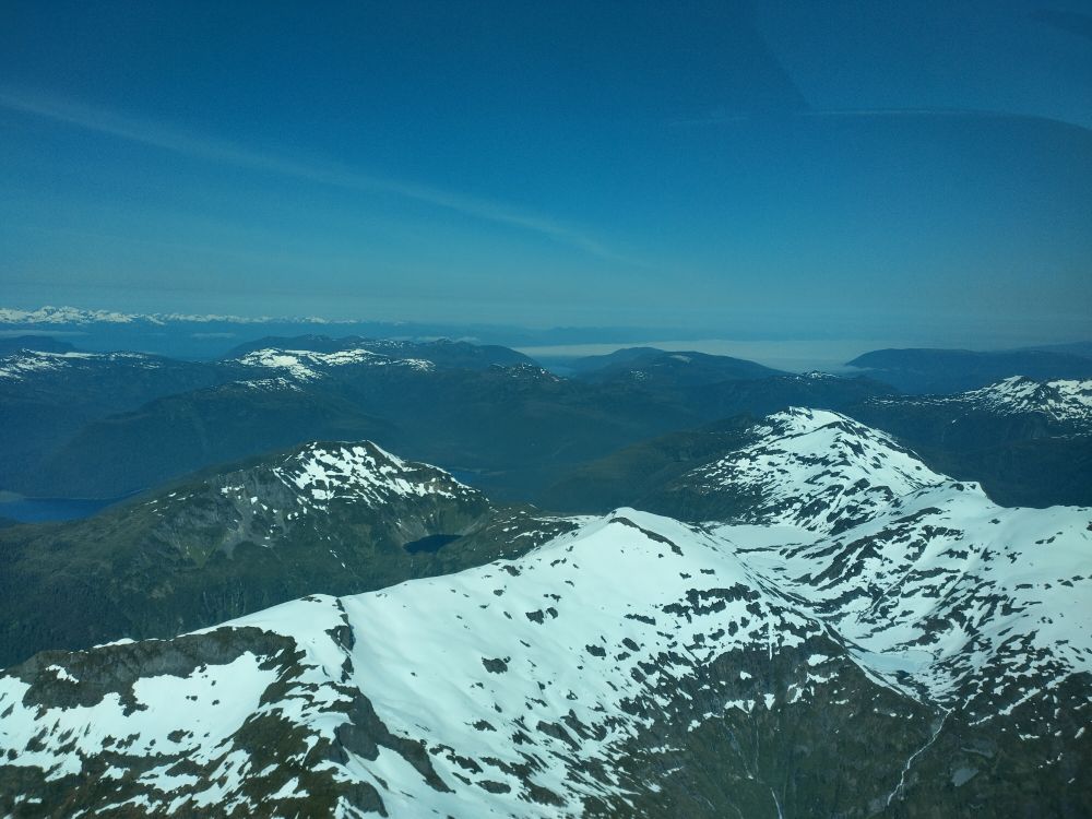 Snowy mountains in the sun on southern Xootsnoowú (Admiralty Island, Alaska) from the air.