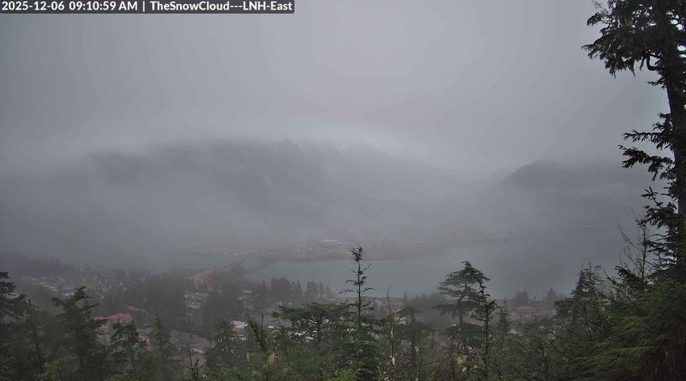 A Snowcloud Communications webcam view of downtown Juneau Alaska at 9:10am 12/6/2025 showing rain & clouds up the mountains.