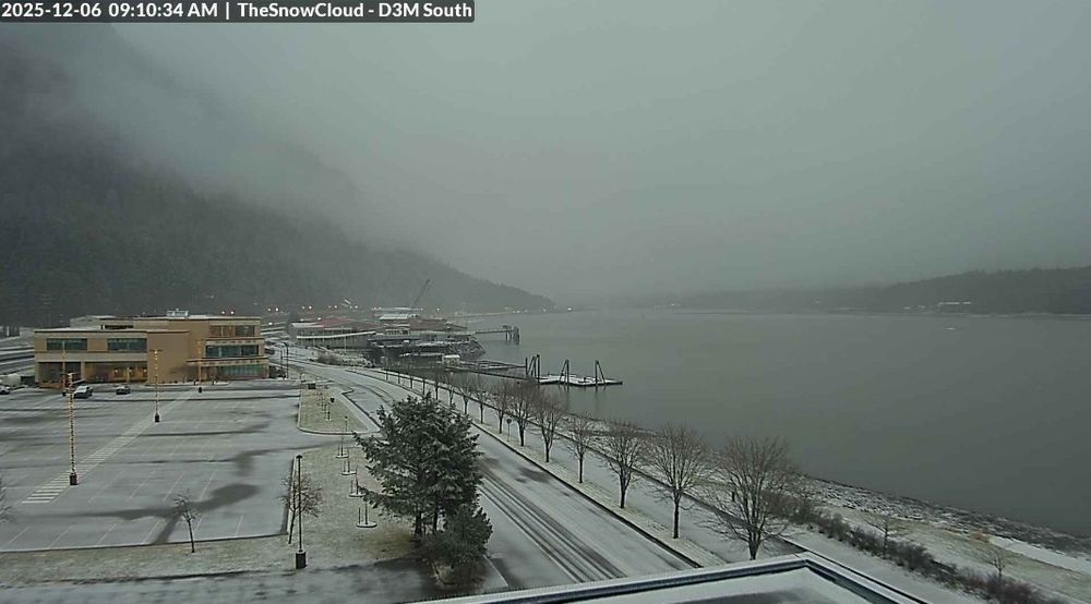 A Snowcloud Communications webcam view of channel drive in Juneau Alaska at 9:10am 12/6/2025 showing snow on the roads at sealevel.