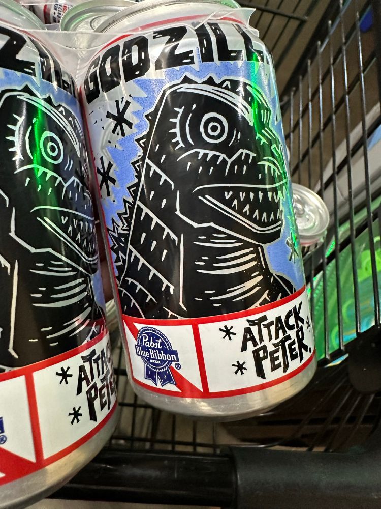 Limited edition PBR can featuring a comics style black and white Godzilla head in blue background and it says “ATTACK PETER”