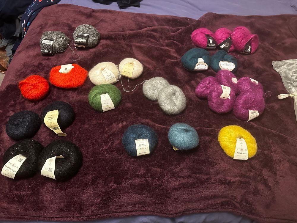 More than two dozen skeins of mohair yarn sorted by color. 