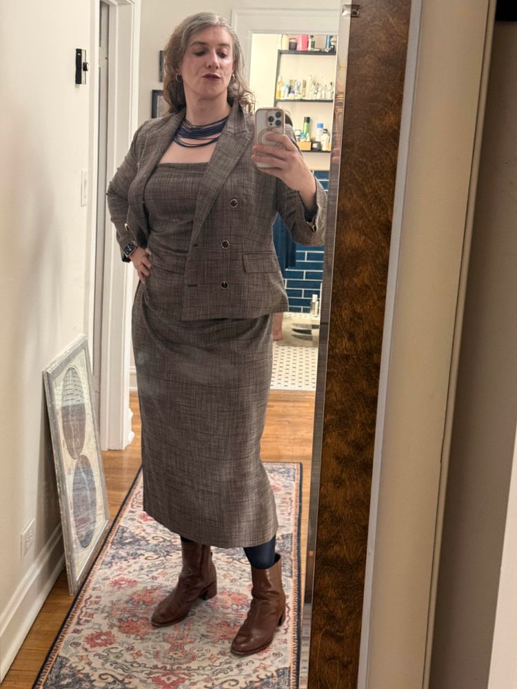 Maggie wearing d plaid dress and cropped jacket but with jacket open