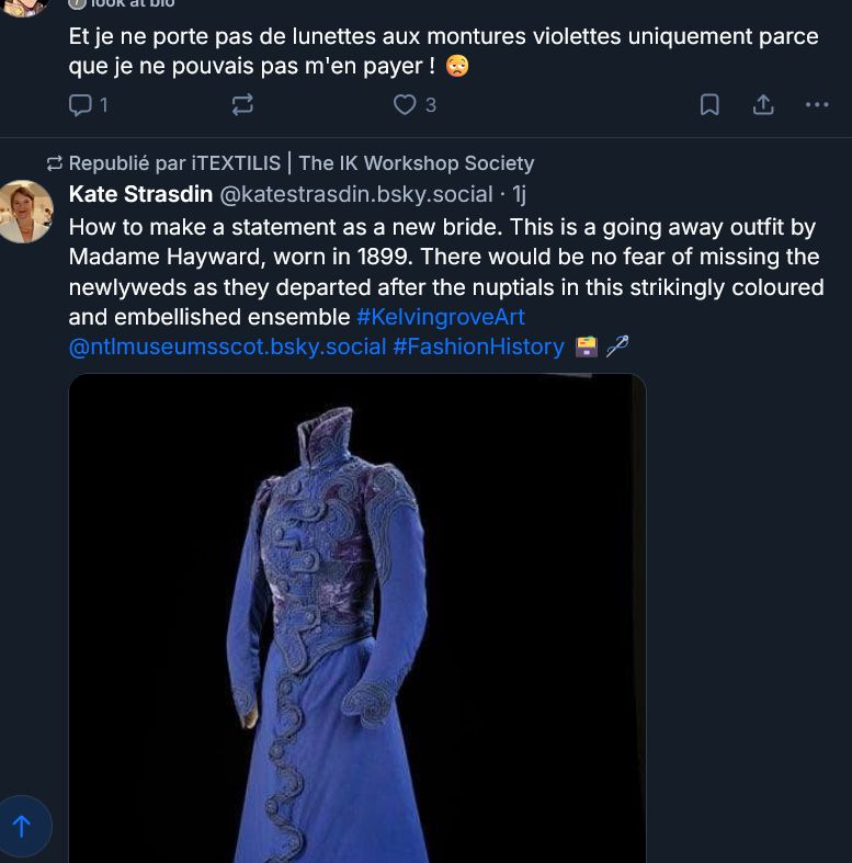 capture d'écran de ma timeline, juste en dessous du post de Tropical, un post de Kate Strasdin, historienne du costume qui parle d'une robe de mariée de 1899. Une photo de la robe accompagne le post, elle est longue, à manches longues, un très haut col droit, des broderies qui forment des boutonnières croisées qui serpentent, toute violette, plutôt mauve foncé, avec des parties plus violettes