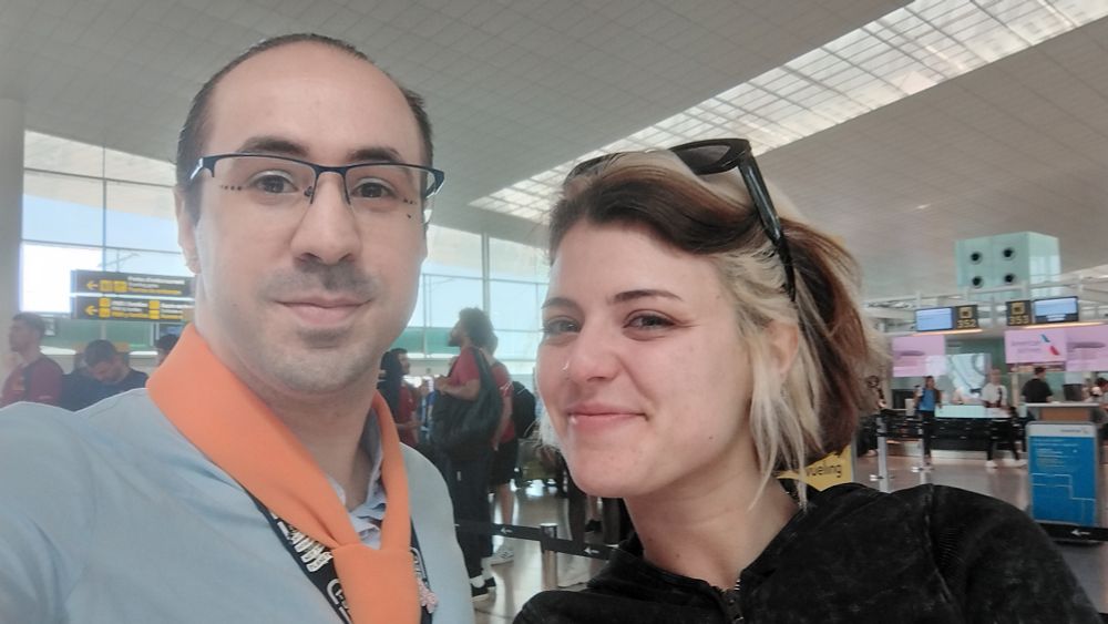 Selfie en el aeropuerto con uniforme del trabajo y Alba Reche al lado sonriendo guapísima 