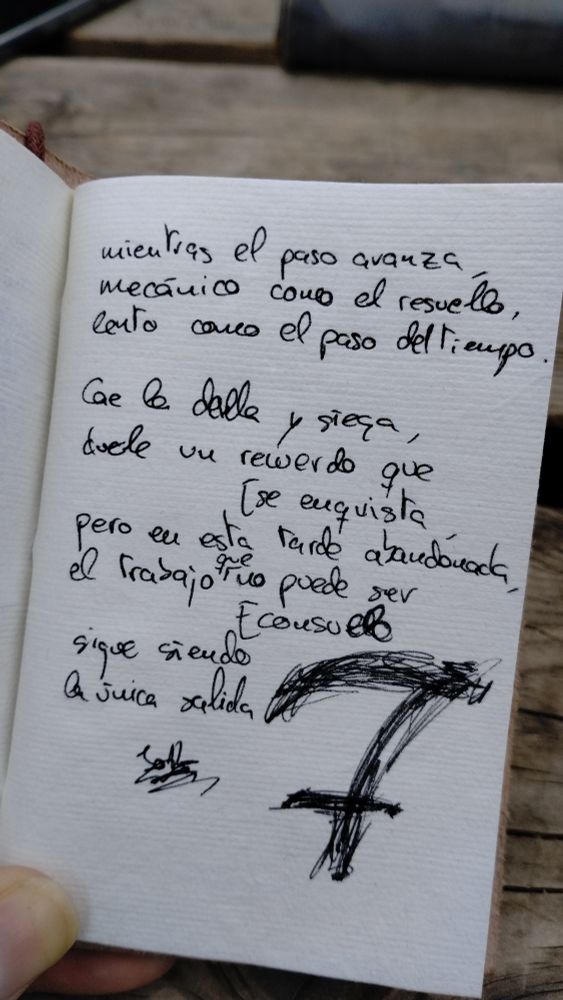 Foto de una página con un poema y un dibujo de una guadaña:

"... mientras el paso avanza,
mecánico como el resuello,
lento como el devenir del tiempo.

Cae la dalla y siega,
duele un recuerdo que se enquista,
pero en esta tarde abandonada,
el trabajo que no puede ser consuelo
sigue siendo
la única salida."