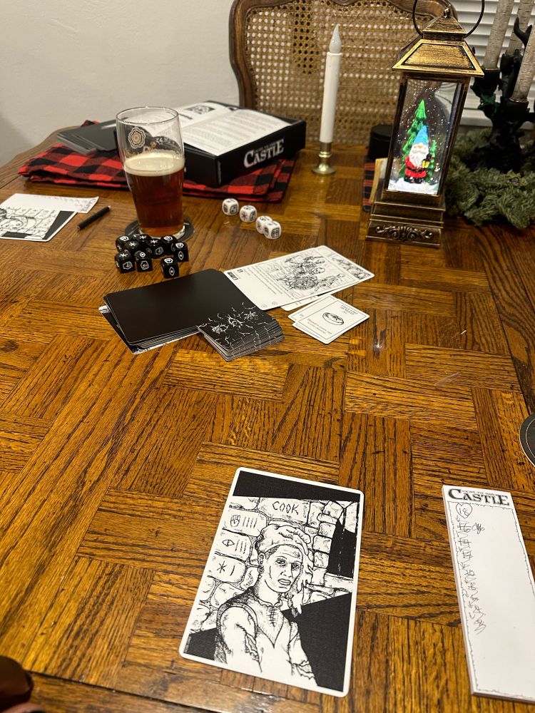 Escape from the Dark Castle game active on the  table with The Cook  in front of me and many hp lost on my player sheet. 
