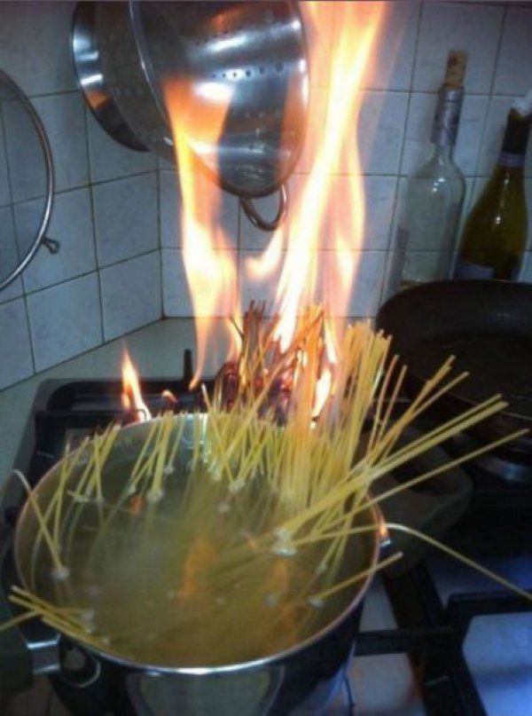 A pot with spaghetti that are on fire